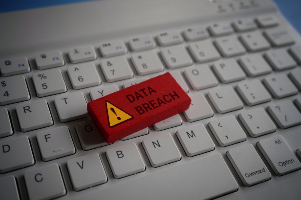 Close up image of computer keyboard and red wooden cube with text DATA BREACH.